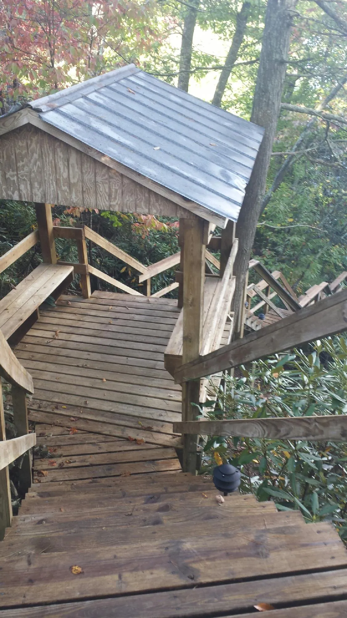 Metal roofed shelter over wooden steps on a wooded walkway — Skylight Repair & Installation work by our crew in King