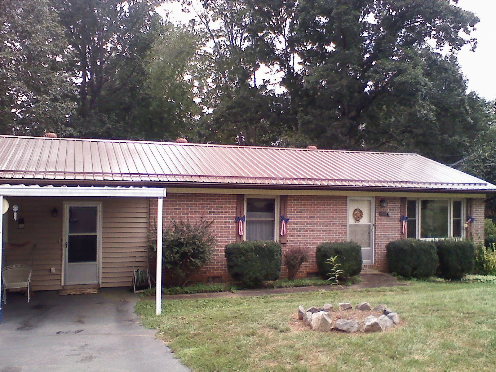 Bronze metal roof and carport on a brick ranch home — Roof Repair work by our crew in King